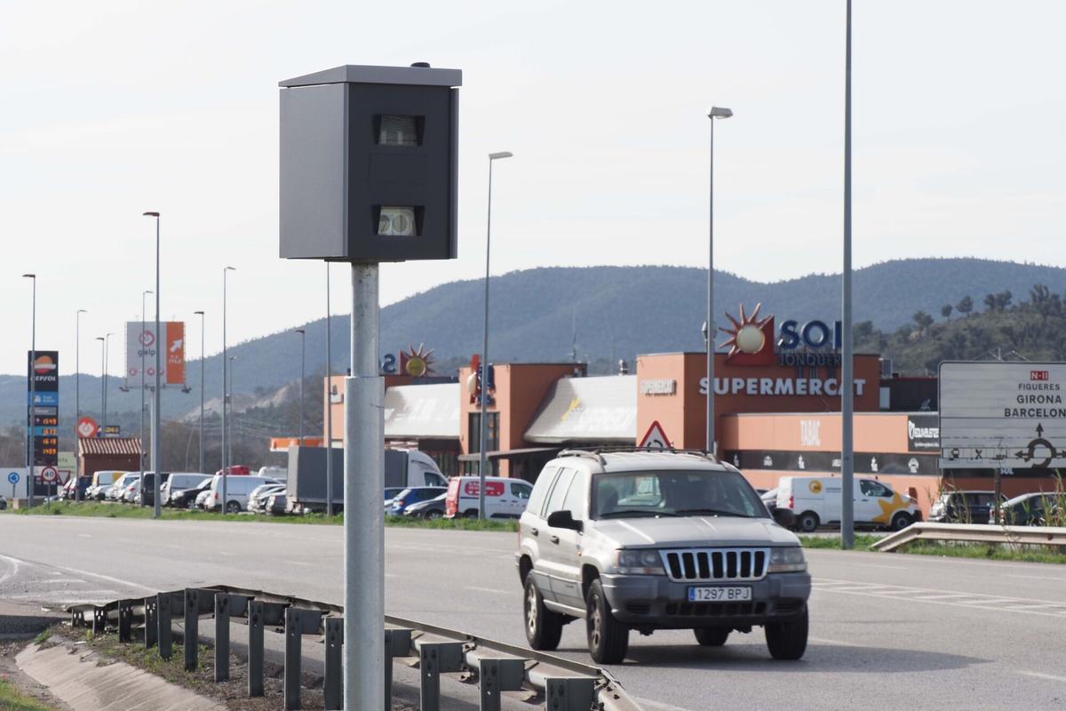 Radar en medio de la carretera con un coche en el fondo.