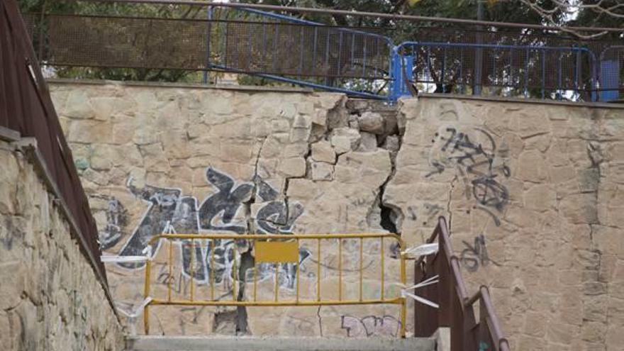 Un muro resquebrajado y cortado con vallas en el Tossal.