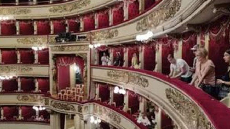 Unos turistas visitan La Scala en Milán.