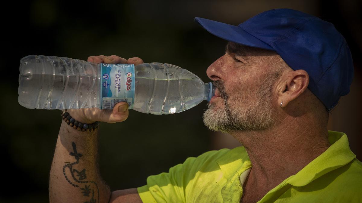 Un operario bebe agua para hidratarse durante su jornada laboral