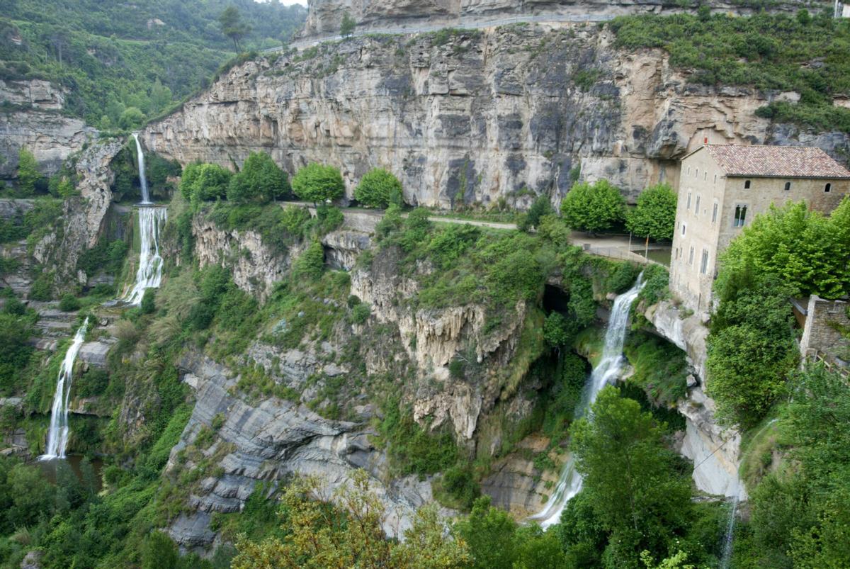 Riells del Fai espacio natural con un monasterio y una cascada.