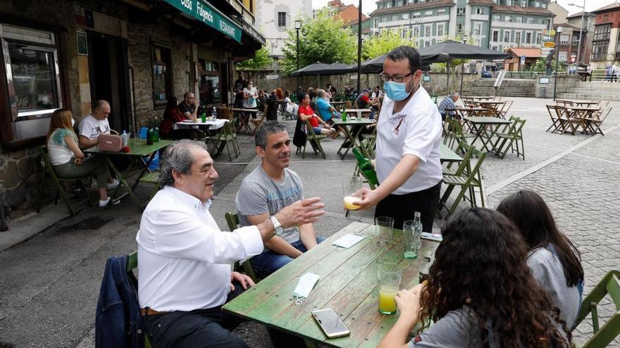 Un camarero sirve sidra en la plaza de Requejo de Mieres.