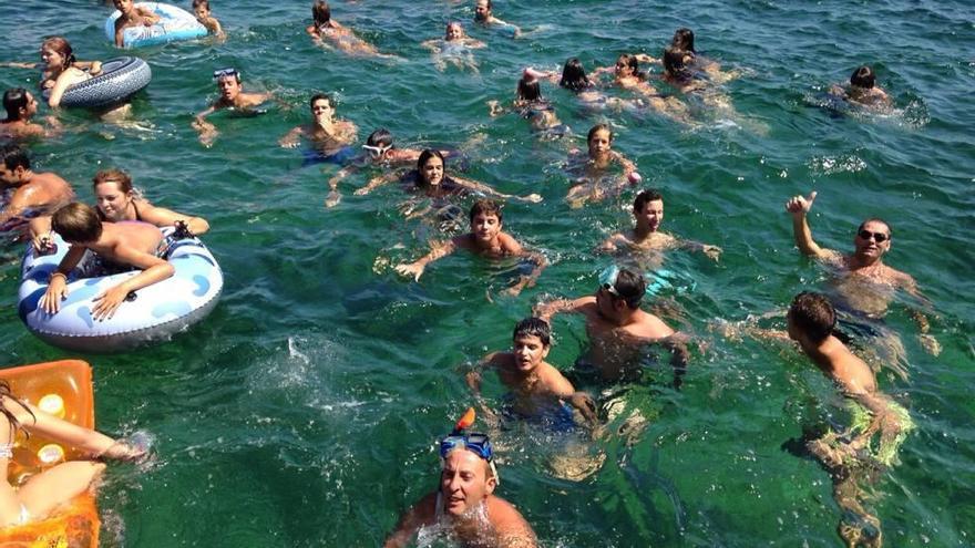 Los bañistas empezaron a concentrarse a mediodía junto a la barca de la organización.