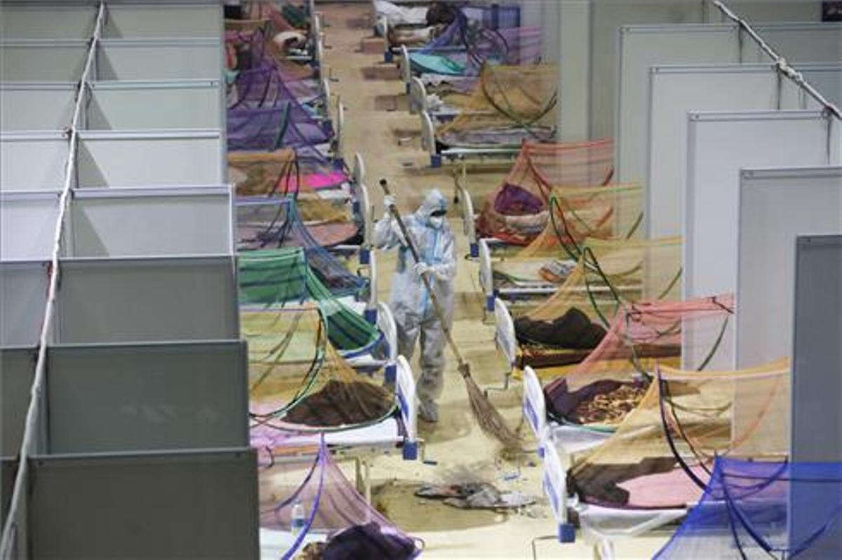 Un operario limpia el suelo de la villa de los Juegos de la Comonwealth que ha sido reconvertida en un centro sanitario para la lucha contra el covid.