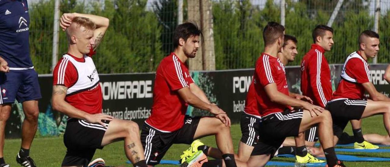 Daniel Wass, en primer plano, realiza estiramientos en el entrenamiento de ayer, junto a los demás titulares. // R. Grobas