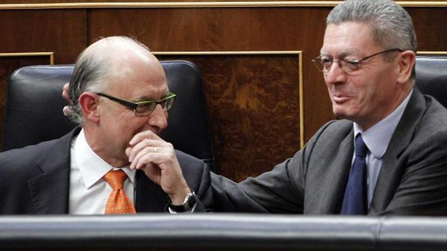 Cristóbal Montoro recibe la felicitación de Alberto Ruiz-Gallardón, ministro de Justicia, tras su discurso en el Congreso.