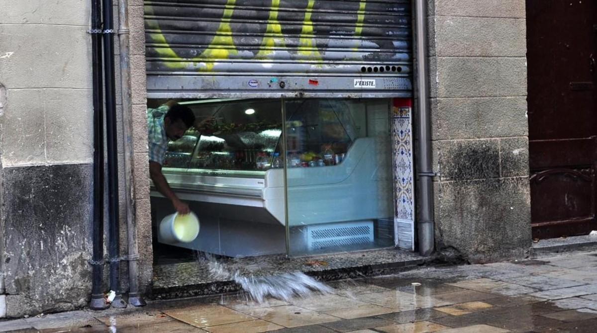 zentauroepp44919716 un local sacando agua desde su tienda tras la tormenta en el180906124816