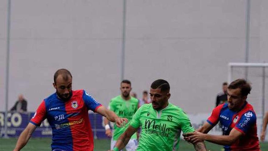 Adrián Llano y Gayoso tratan de robar el balón a Ruano, del Melilla.