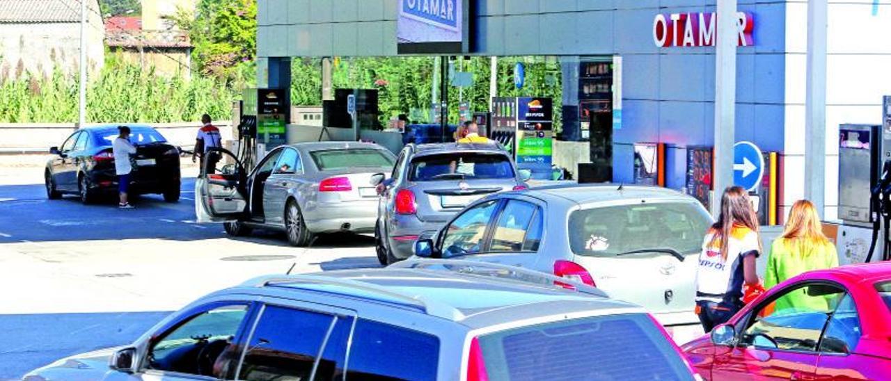 Colas de vehículos lusos repostando ayer al mediodía en una gasolinera de Tui ubicada junto a la frontera.  | // MARTA G. BREA