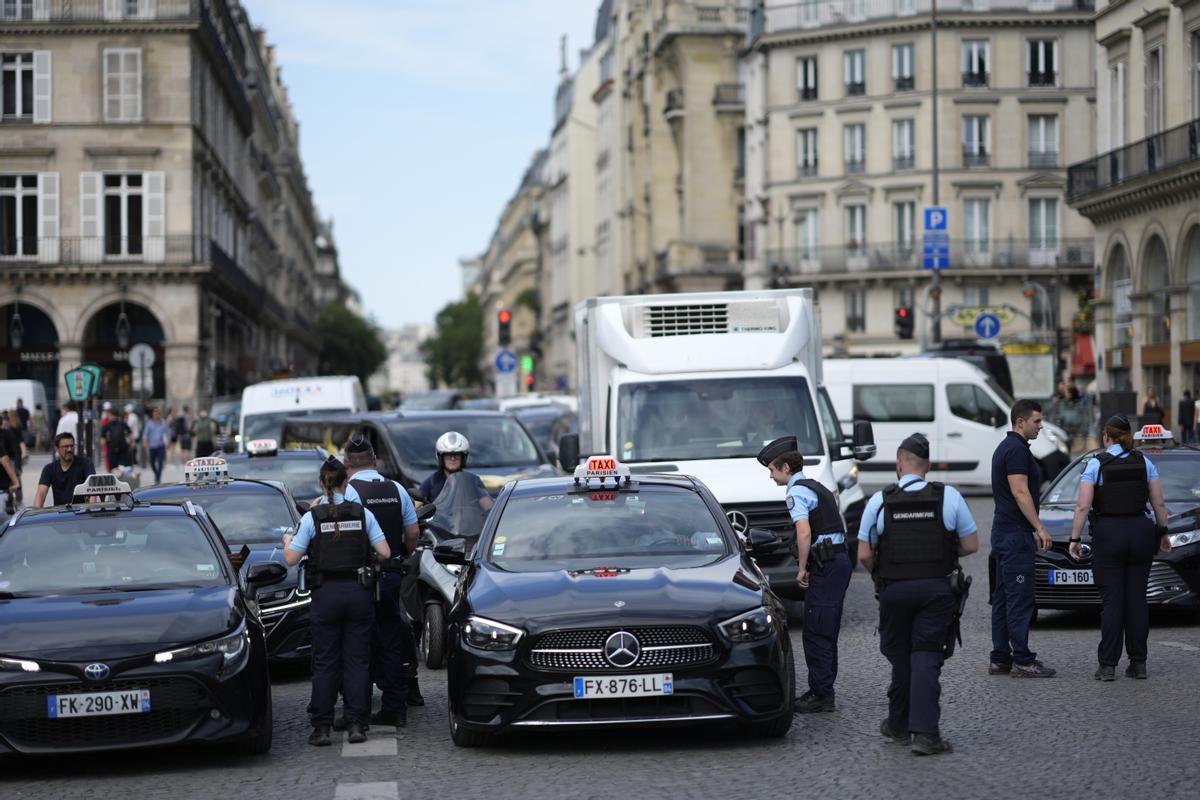 Police officers check vehicles at the security perimeter set up for the Olympic Games, Thursday, July 18, 2024 in Paris. A special kind of iron curtain came down across central Paris on Thursday, with the beginning of an Olympic anti-terrorism perimeter along the banks of the River Seine sealing off a kilometers-long (miles-long) area to Parisians and tourists who hadnt applied in advance for a pass. (AP Photo/David Goldman)