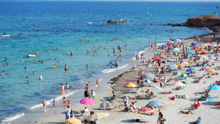 Bañistas en el agua y en la arena.