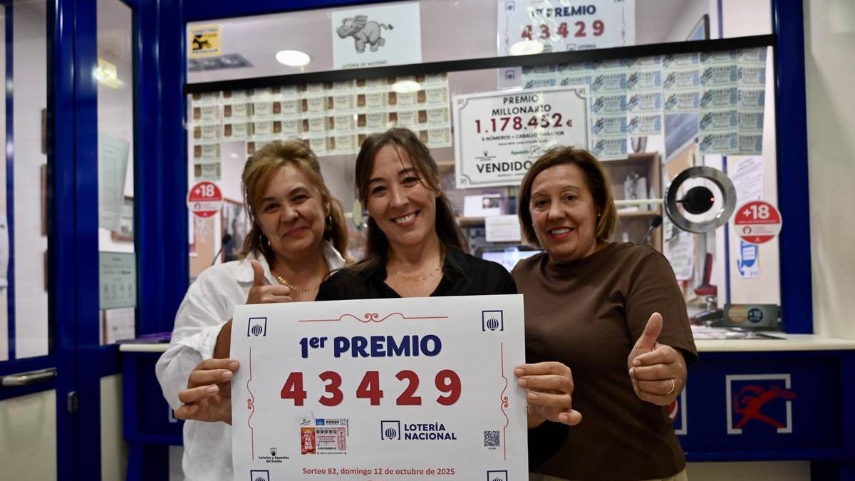 Celia, Kiti y Carmen Portela (de izq. a dcha.) posan con el cartel del primer premio del sorteo extraordinario vendido en su administración, en la calle Michelena.
