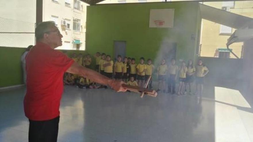 Uno de los voluntarios muestra a los niños y niñas uno de los cohetes de La Passejà.