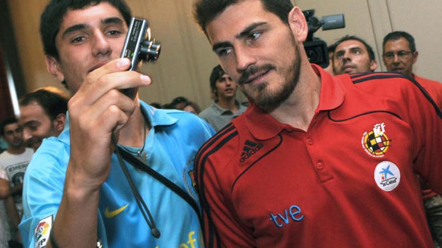 El portero de la selección española de fútbol Iker Casillas se fotografía con un aficionado tras la rueda de prensa celebrada al llegar a Skopje, Macedonia.