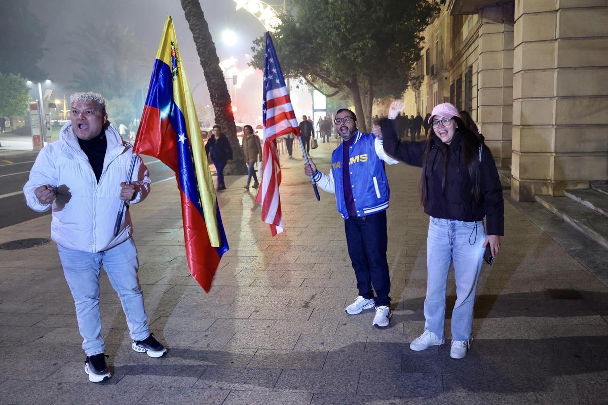 Tres venezolanos portan una bandera de su país y otra de Estados Unidos, este martes en Teniente Flomesta, en Murcia.