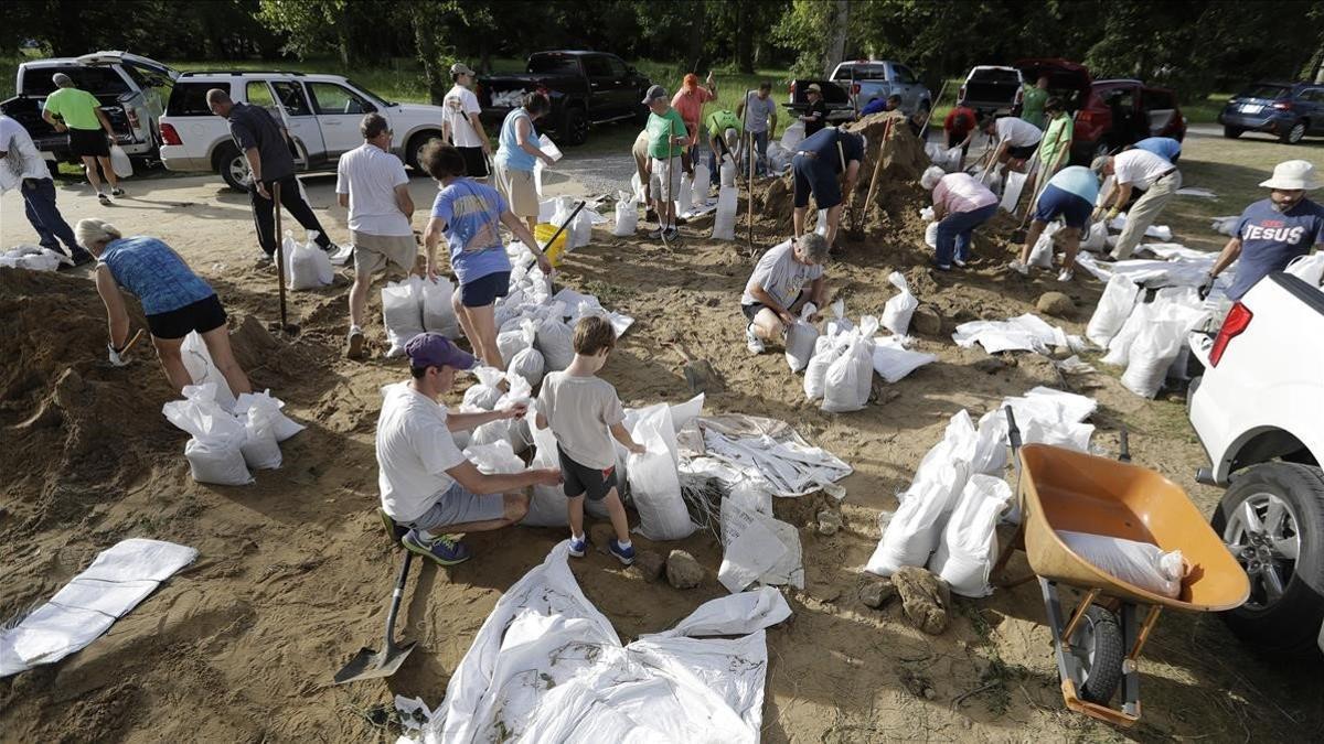 Vecinos de Baton Rouge colocan bolsas de arena para afianzar estructuras ant la inminente llegada de 'Barry'.