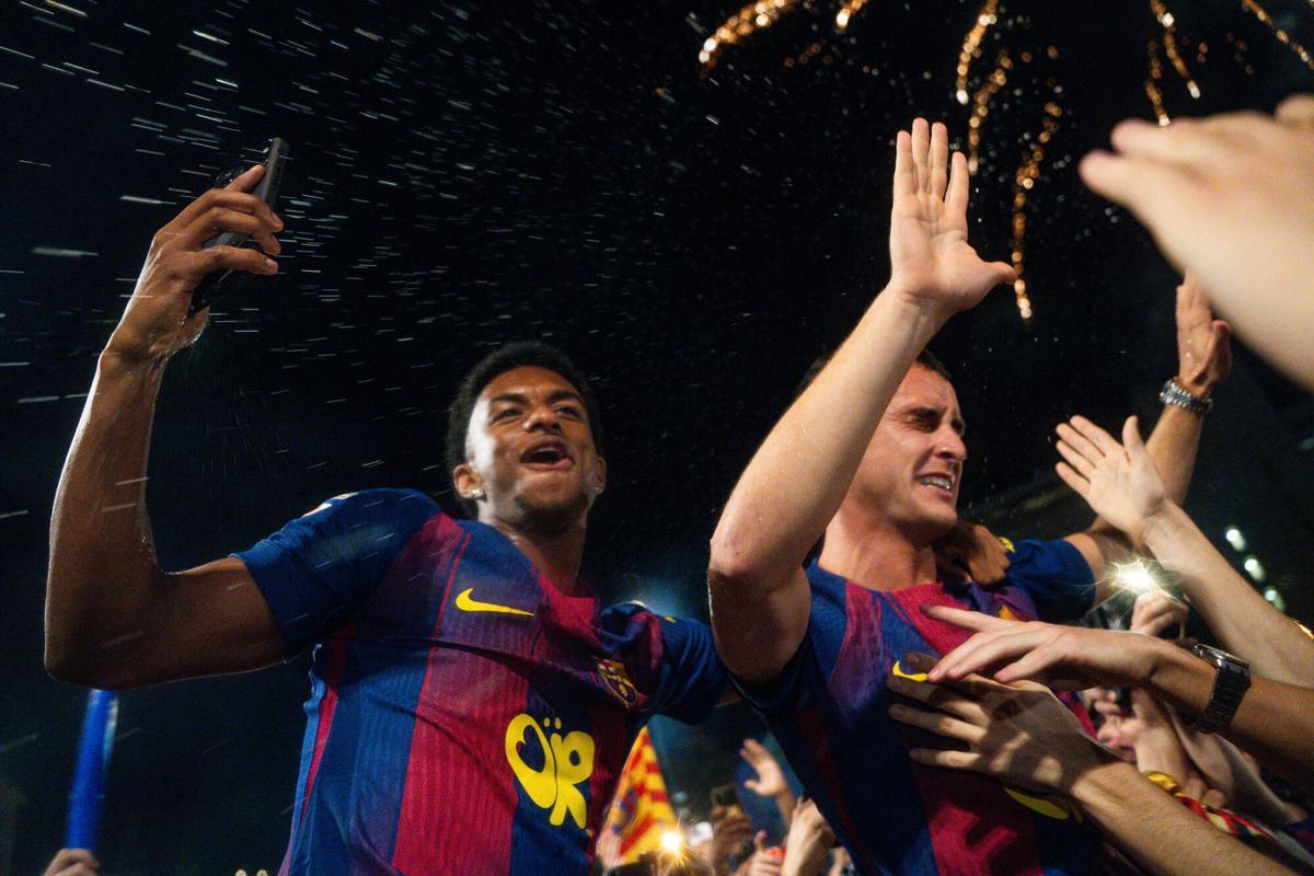 Marc Casadó y Alejandro Balde celebran el título de Liga, conseguido contra el Real Madrid, junto a los aficionados culers en la Plaça de Catalunya. Barcelona. 11/05/2026. Deporte. Barcelona, Catalunya, España, Plaça de Catalunya, deporte, futbol, FCBarcelona, Real Madrid, Clásico, victoria, Liga 2025/2026, campeones, celebración, fiesta, trofeo, Marc Casadó, Alejandro Balde, jugadores, La Masia