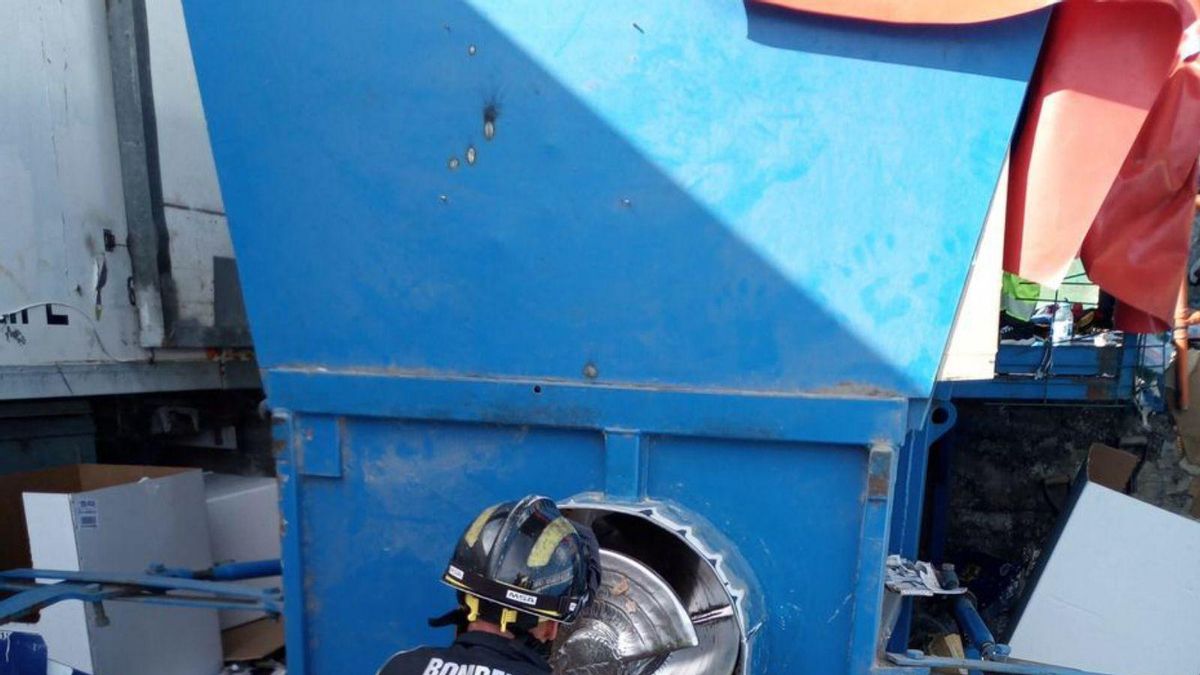 Un bombero trabaja en la máquina donde quedó atrapada una persona.