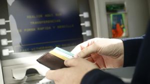 Un cliente saca dinero de un cajero automático.
