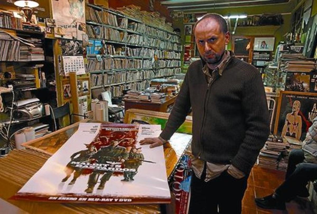 Una botiga plena de cine 8 Joan Vall, propietari de Cinemascope, amb el cartell d’una pel·lícula.