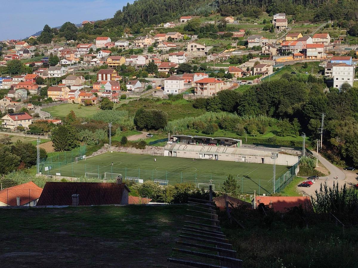 Una vista del campo de fútbol de A Graña, en Bueu. La adquisición de terrenos para los accesos y zonas de esparcimiento se realizará por el costado izquierdo de la imagen.