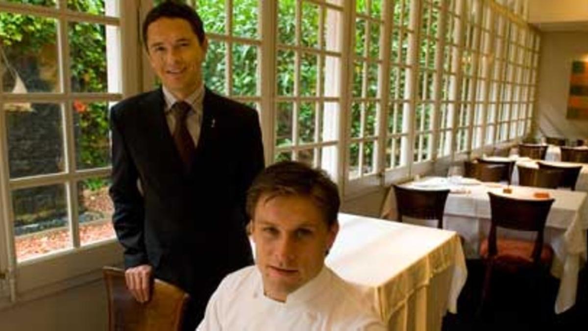 Joan Junyent (de pie) con el chef Carlos Alconchel, en las mesas del Windsor que dan al jardín. Foto: JOAN PUIG