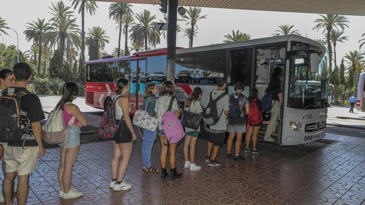 Jóvenes esperan en la estación de autobuses de Elche para coger uno de los nuevos autobuses de la Generalitat