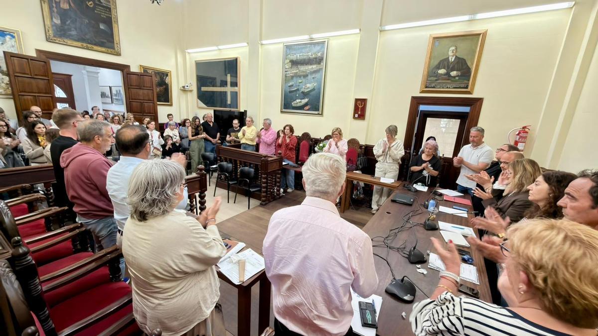 Los miembros de la corporación y el público aplauden al finalizar el minuto de silencio en memoria del edil socialista.