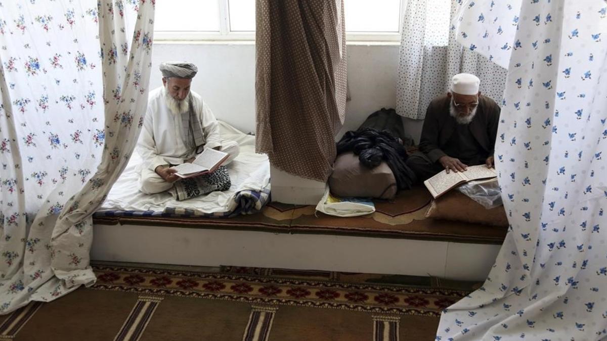 Musulmanes afganos leen versos del Corán en una mezquita de la ciudad de Kabul.