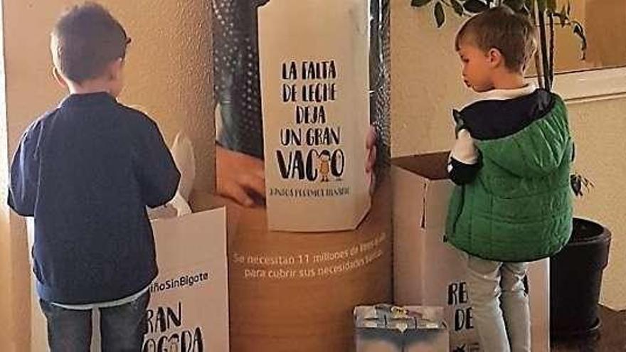 Dos niños colaborando con la iniciativa.