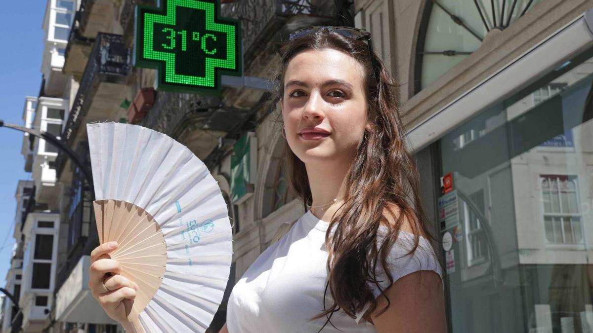 Una mujer se abanica en plena ola de calor en Vigo.