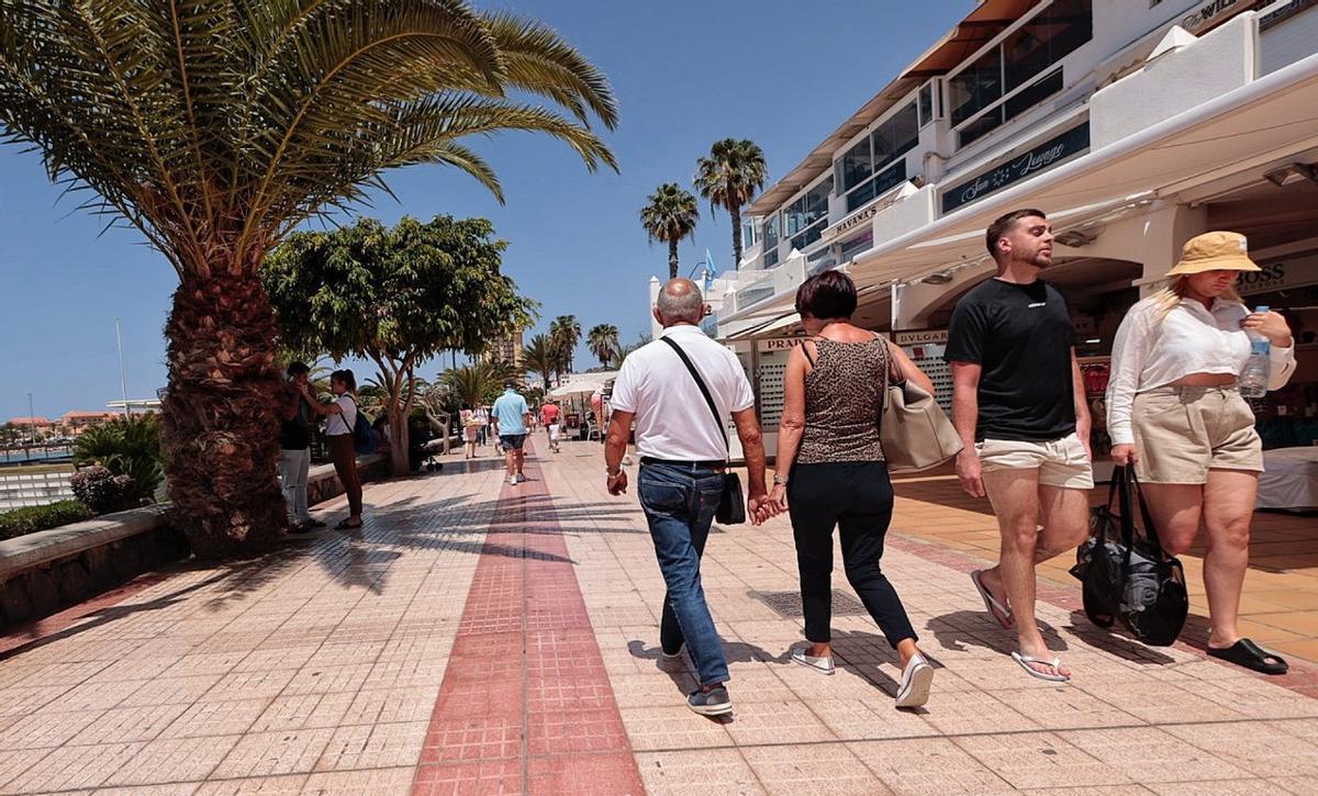 Varios turistas pasean por una de las zonas comerciales de Los Cristianos. |