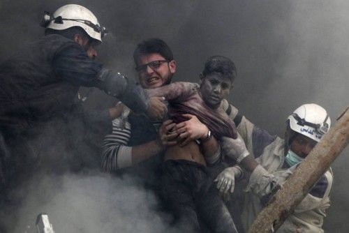 Hombres rescatan a un niño de entre los escombros después de que barriles explosivos cayeran por las fuerzas leales al presidente de Siria, Bashar Al-Assad en el barrio de Al-Shaar de Alepo, en Siria.