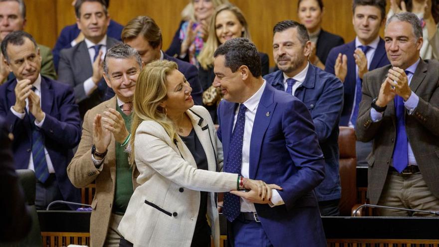 La consejera Carolina España y el presidente Juanma Moreno se felicitan tras la aprobación.