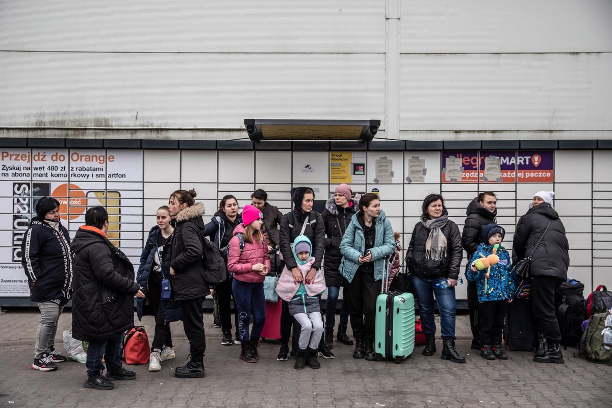 Ucranianos que han escapado de su país esperan un autobús para seguir su viaje, en un centro temporal para refugiados levantado en el edificio en desuso de Tesco Plc, en Przemsysl, Polonia.