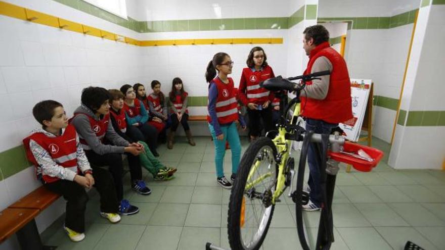 Arriba, alumnos de Primaria del colegio público El Quirinal reciben indicaciones de un representante de la Fundación Mapfre sobre el uso de la bicicleta. A la derecha, alumnos de Secundaria del colegio Principado fabrican un motor stirling en el marco de las jornadas culturales sobre el romanticismo.