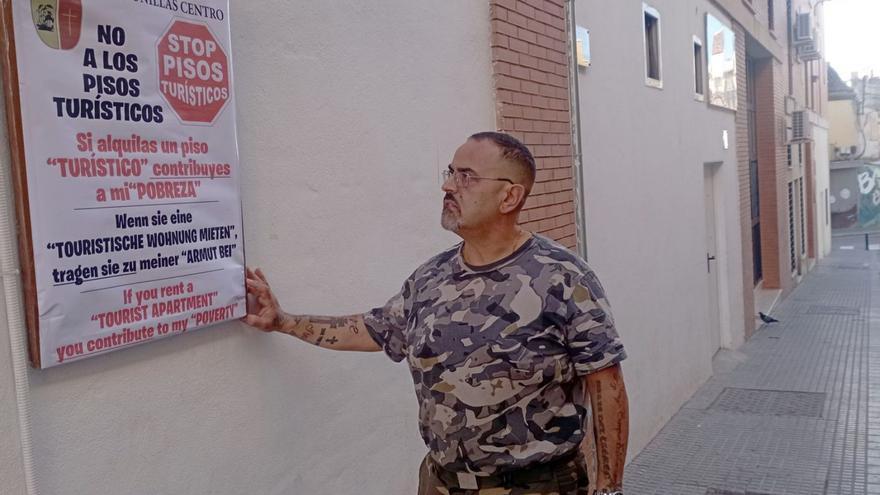 El presidente vecinal Curro López, con el cartel de la campaña contra los pisos turísticos en Lagunillas.