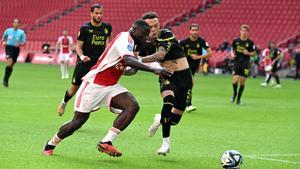 Quilindschy Hartman y Brian Brobbey pugnan por un balón durante el Ajax - Feyenoord