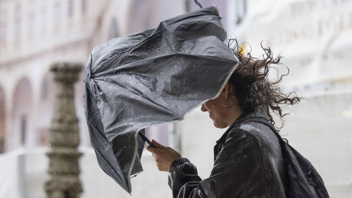 Una mujer camina por Santiago durante una jornada de temporal esta semana