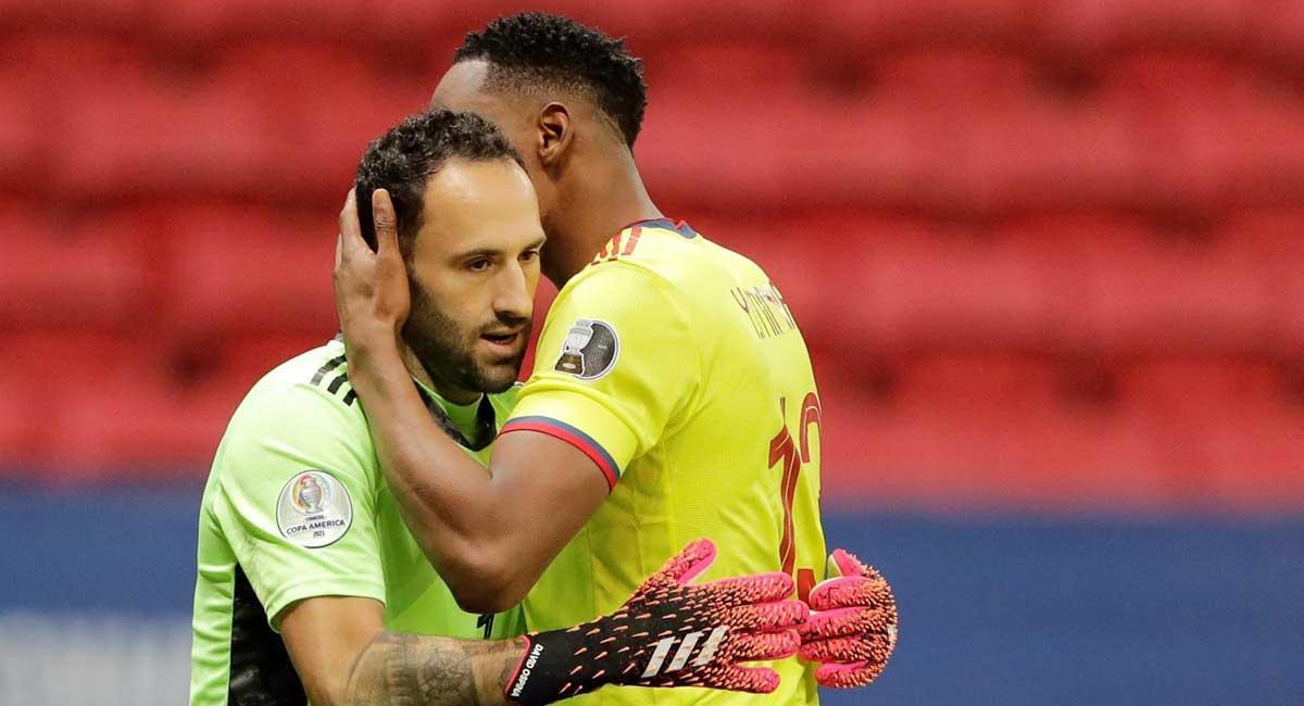 Yerry Mina transmite ánimos a David Ospina antes de un lanzamiento.