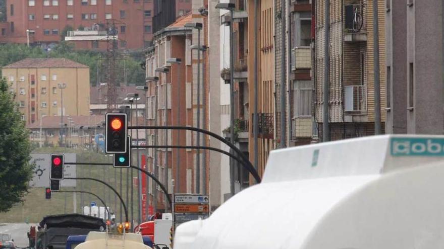 Varios camiones, en el cruce de Cuatro Caminos, en dirección al puerto de El Musel.