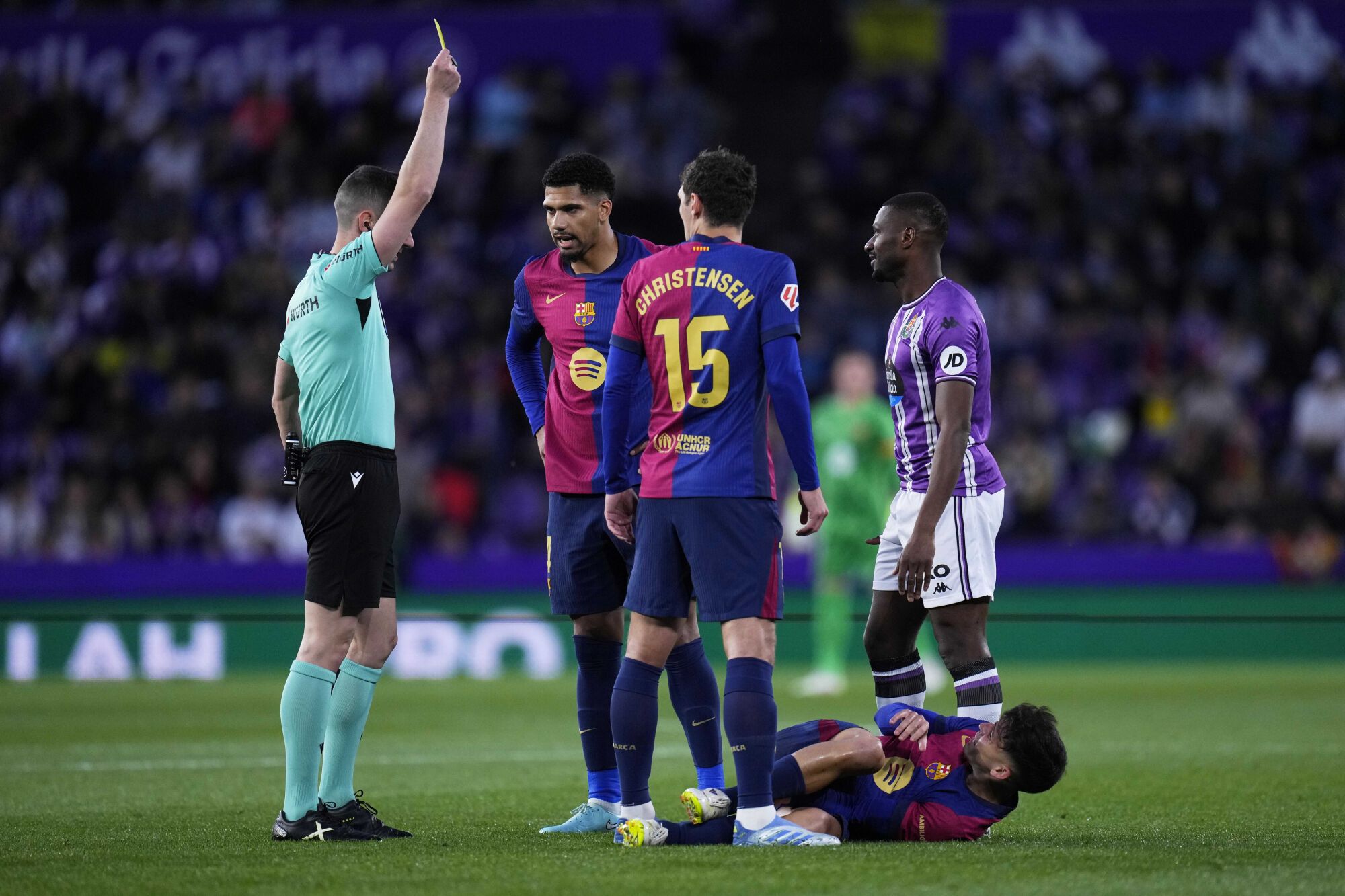 Referee Alejandro Muniz Ruiz shows a yellow card to Valladolid's Mamadou Sylla, right, during the Spanish La Liga soccer match between Valladolid and FC Barcelona at the Jose Zorrilla stadium in Valladolid, Spain, Saturday, May 3, 2025. (AP Photo/Manu Fernandez). EDITORIAL USE ONLY/ONLY ITALY AND SPAIN
