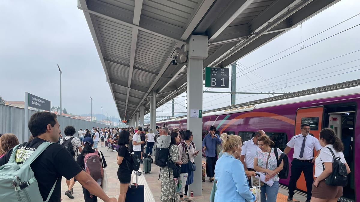 Pasajeros del trazado Santiago-Ourense con destino Madrid siendo desalojados del tren tras quedar parado en la estación compostelana.