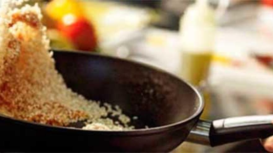 Un cocinero prepara arroz en una cocina.