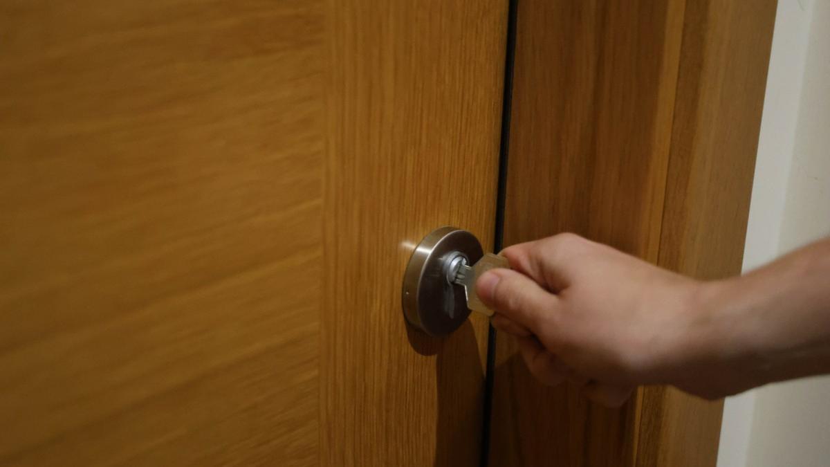 Mano abriendo la puerta de una casa