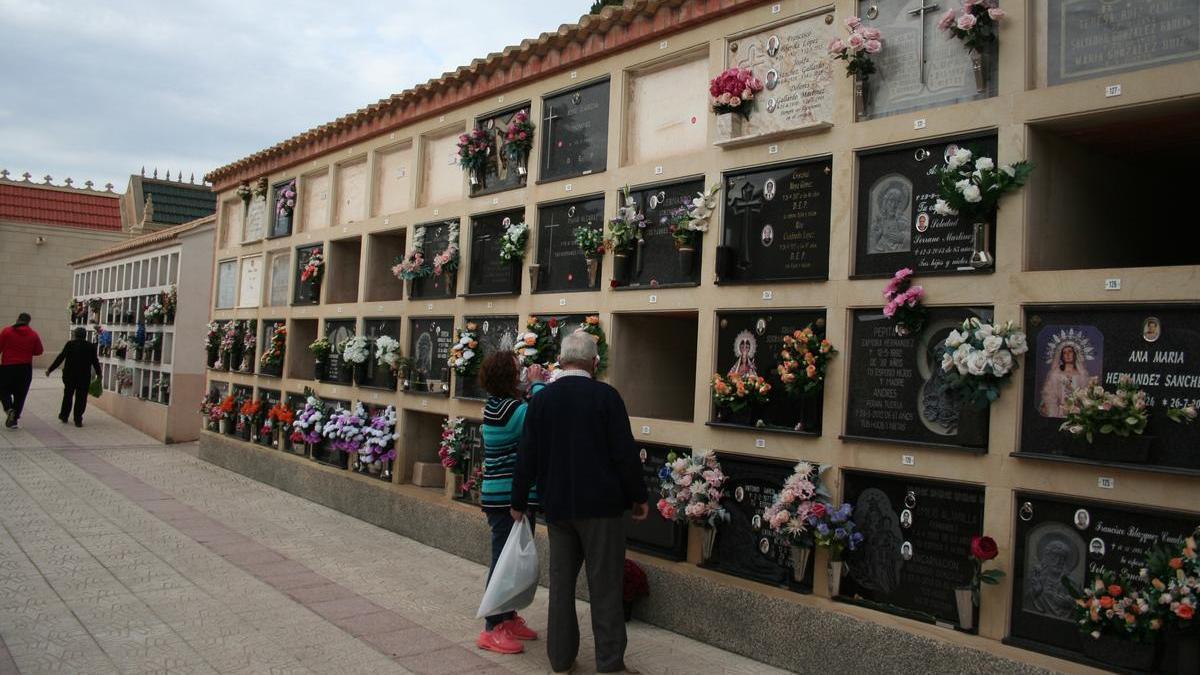 Dos lorquinos visitan a sus difuntos en el cementerio de San Clemente.