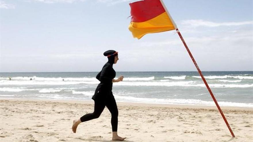 Una mujer en burkini en una playa. // EP