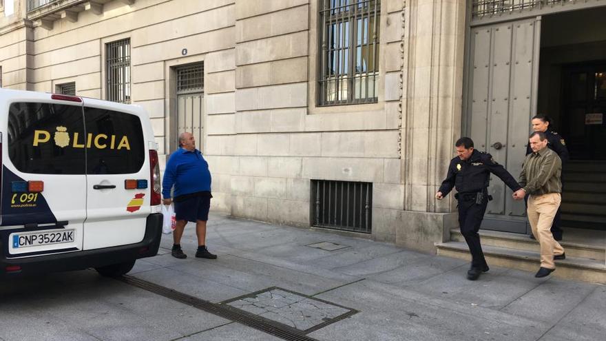 Dos agentes escoltan al acusado. // C. García