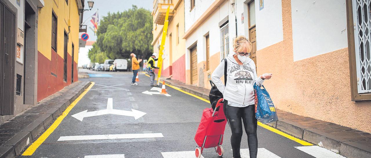 Una mujer vuelve a casa por una de las vías que llevan al consistorio chasnero tras hacer la compra en uno de los mercados del barrio.