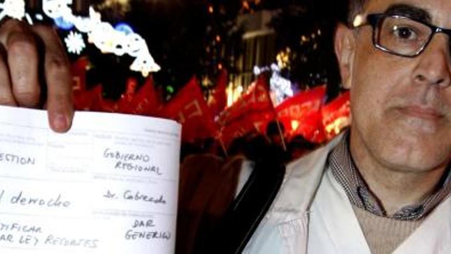 Un médico cabreado muestra una &quot;receta contra el derroche&quot; en la protesta de ayer.